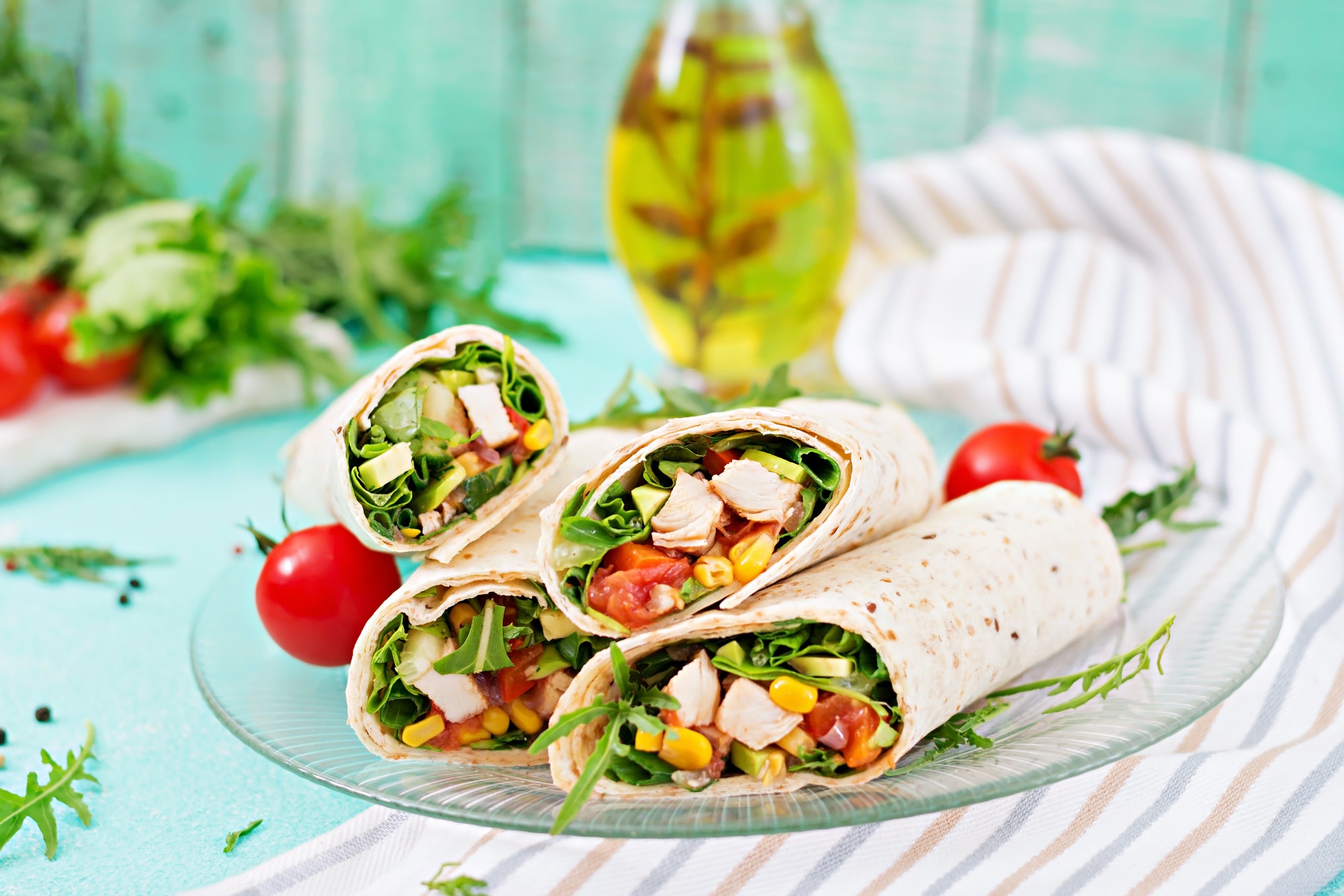 Burritos wraps with chicken and vegetables on light background. Chicken burrito, mexican food.