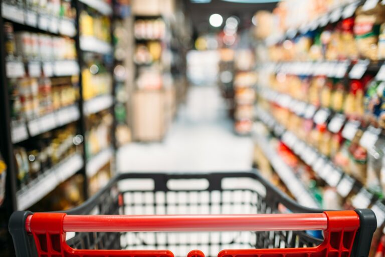 Shopping cart between shelves in food store