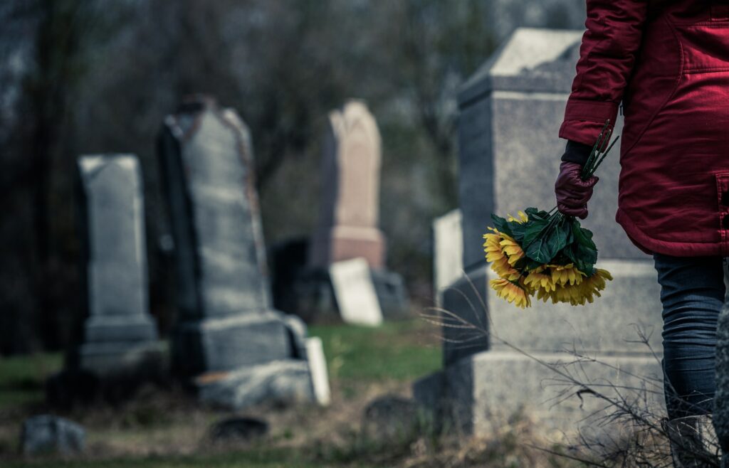 Close-up of a Sad in front of a Gravestone.