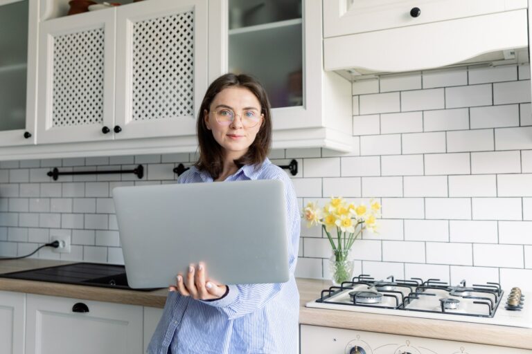 Portrait of young casual woman working or studying using laptop