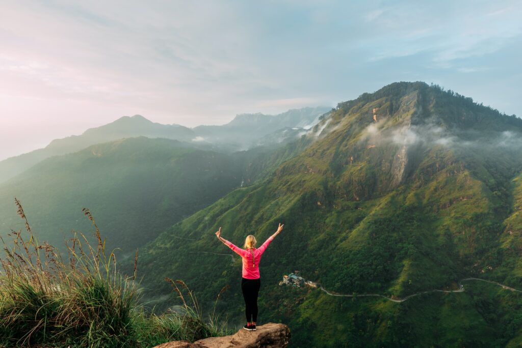 Girl meets sunrise in the mountains. Girl traveling to Sri Lanka. Mountain sports
