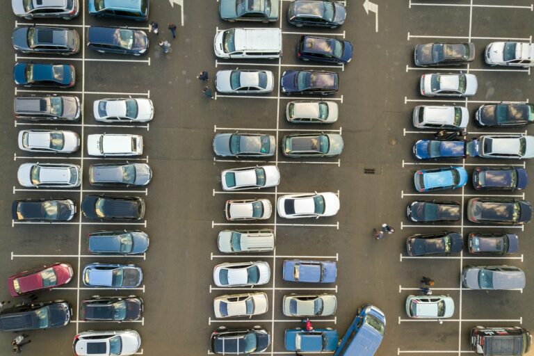 Top view of many cars parked on a parking lot.