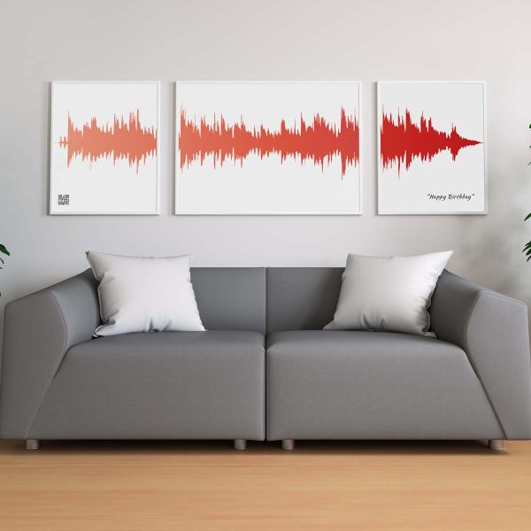 poster i tre delar på vägg ovanför soffa med rödaktig horisontell ljudvåg