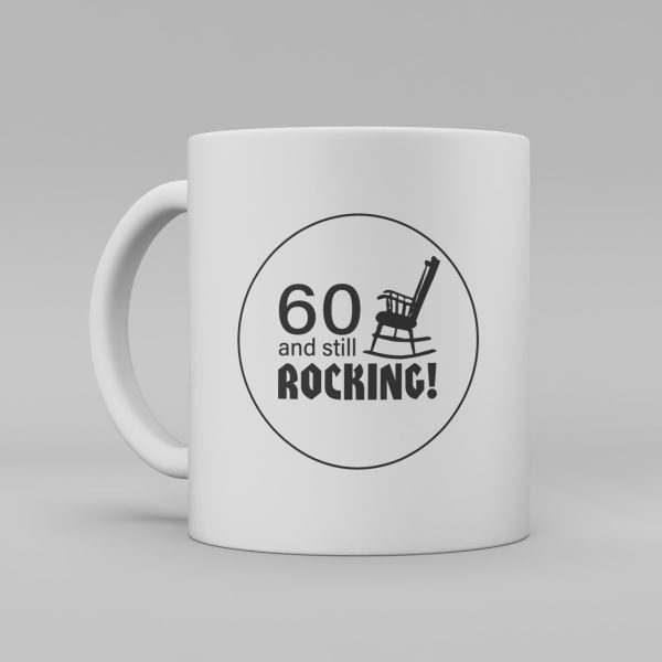 En vit keramikmugg med med en svart siluett av en gungstol och texten: "60 and still rocking"