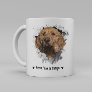 Vit keramikmugg med illustration av ett hundhuvud som "tittar ut genom" ett illustrerat hål. Hunden är av rasen Basset Fauve de Bretagne