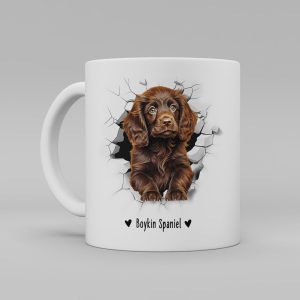 Vit keramikmugg med illustration av ett hundhuvud som "tittar ut genom" ett illustrerat hål. Hunden är av rasen Boykin Spaniel