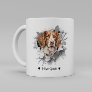 Vit keramikmugg med illustration av ett hundhuvud som "tittar ut genom" ett illustrerat hål. Hunden är av rasen Brittany Spaniel