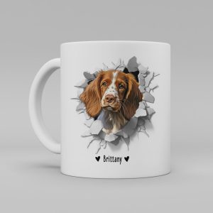 Vit keramikmugg med illustration av ett hundhuvud som "tittar ut genom" ett illustrerat hål. Hunden är av rasen Brittany