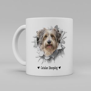 Vit keramikmugg med illustration av ett hundhuvud som "tittar ut genom" ett illustrerat hål. Hunden är av rasen Catalan Sheepdog