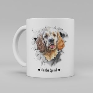 Vit keramikmugg med illustration av ett hundhuvud som "tittar ut genom" ett illustrerat hål. Hunden är av rasen Clumber Spaniel