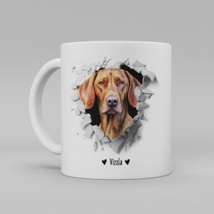 Vit keramikmugg med illustration av ett hundhuvud som "tittar ut genom" ett illustrerat hål. Hunden är av rasen Vizsla