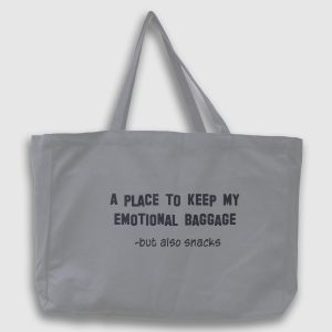 Foto på en grå tygväska med svart text på engelska: "A place to keep my emotionel bagage, but also snacks"