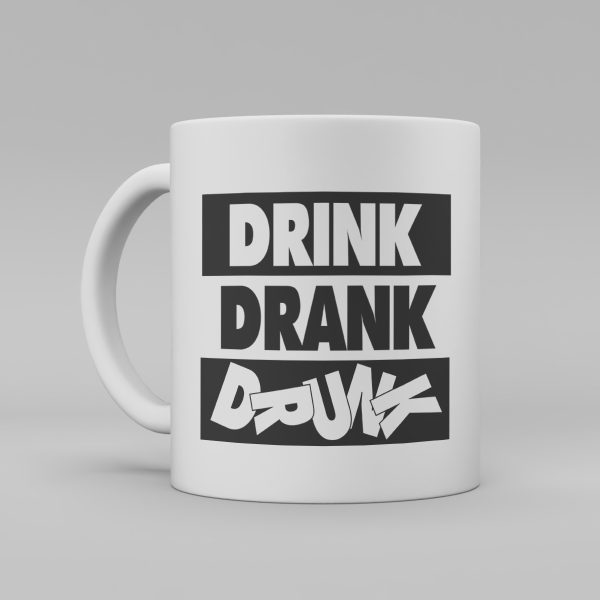 Vit keramikmugg med svart text på engelska : "Drink, drank och drunk" sista ordet (drunk) där ligger bokstäver huller om buller.
