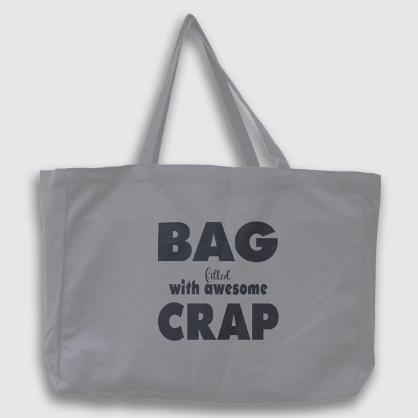 Foto på grå tygväska med svart engelsk text: "Bag filled with awesome crap"