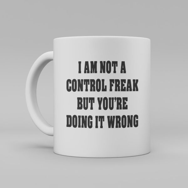 Vit keramikmugg med svart, engelsk text: "I am not a control freak but you're doing it wrong"