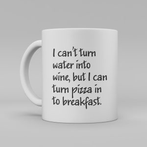 Vit keramikmugg med svart text; I can't turn water into wine, but I can turn pizza into breakfast.