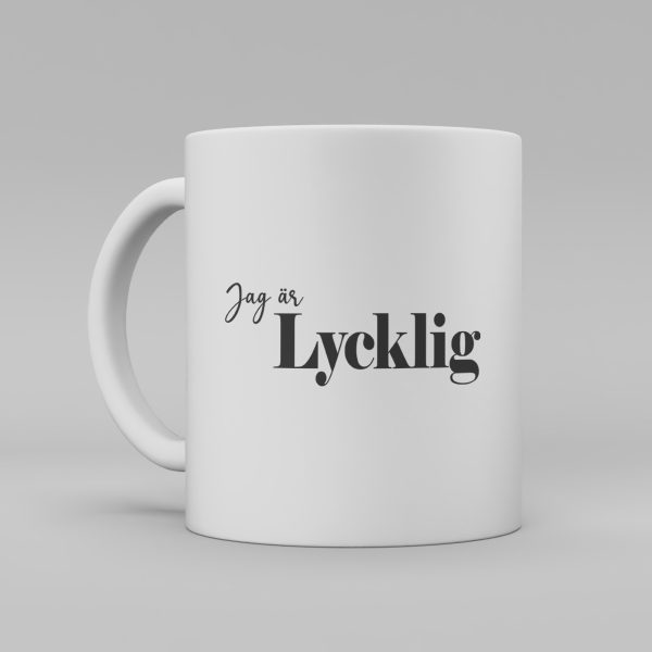 Vit keramikmugg med svart text: "Jag är lycklig"