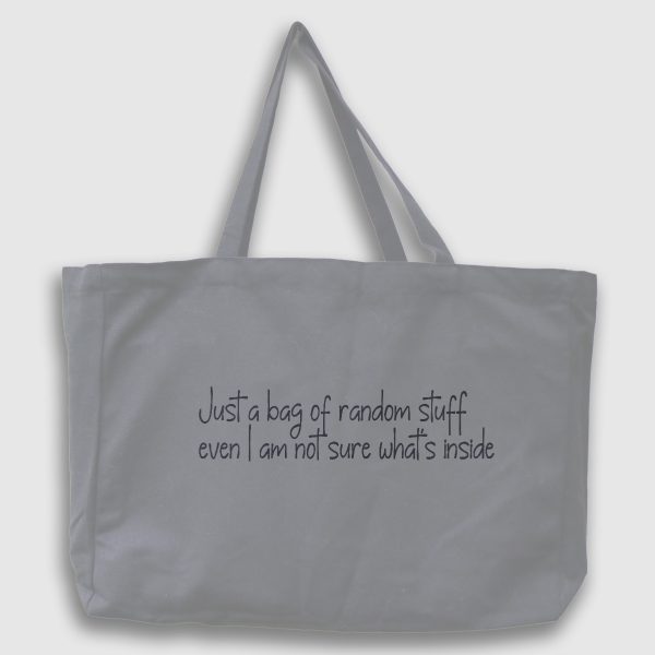 Foto på grå tygväska med svart text på engelska: "Just a bag of random stuff even I am not sure what's inside"