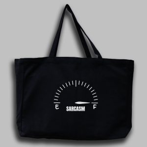 En svart tygväska med vit text: "Sarcasm" ovanför ordet en mätarställning där pil pekar på full