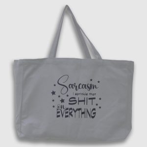 Foto på grå tygväska med svart text på engelska: "Sarcasm I sprinkle that shit on everything"