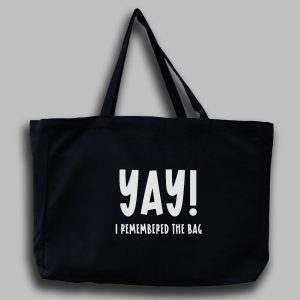 Svart tygväska med vit engelsk text: "Yay! I remembered the bag"