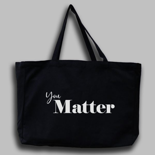 Svart tygväska med vit engelsk text: "You matter"