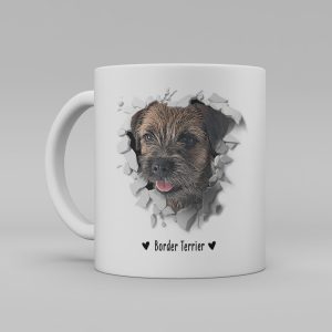 Vit keramikmugg med illustration av ett hundhuvud som "tittar ut genom" ett illustrerat hål. Hunden är av rasen Border Terrier