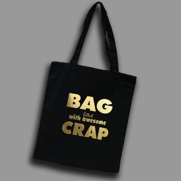 Svart tygkasse med guldtext på engelska: "Bag filled with awesome crap"