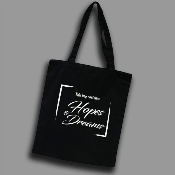 Svart tygkasse med vit text på engelska: "This bag contains hope & dreams"