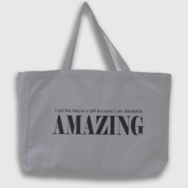 Foto av grå tygväska med svart text på engelska: "i got this bag as a gift because i am absolutly amazing"