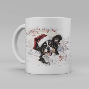 Foto av en vit keramikmugg med illustration av en hund med en tomteluva. Hunden är av rasen Papillon