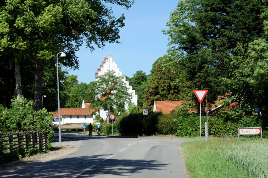 Hvid landsbykirke, træer og en landevej