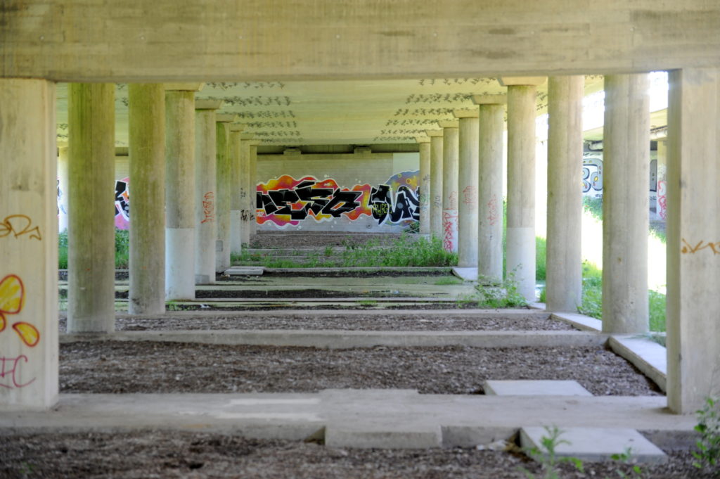 Betonkonstruktion med søjler. På betonvæg ses graffiti