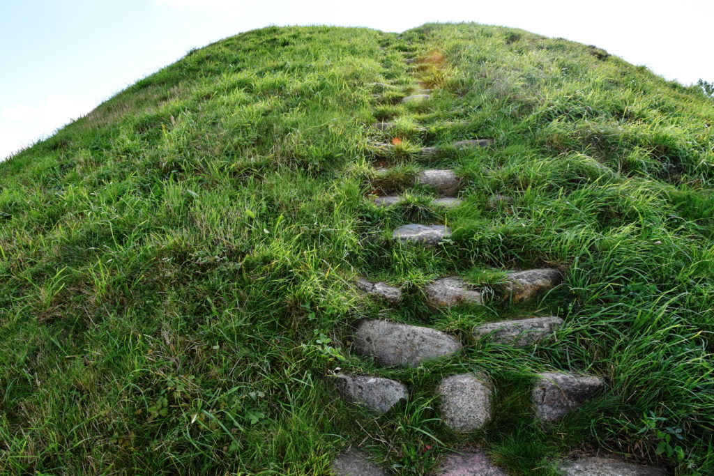 Ujævn trappe bygget af marksten. Trappen fører op at gravhøjens side.