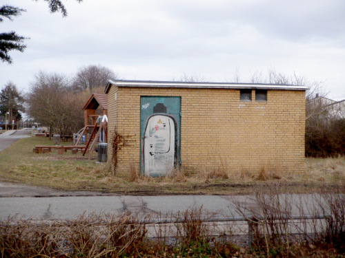 Gult murstensskur med graffiti.