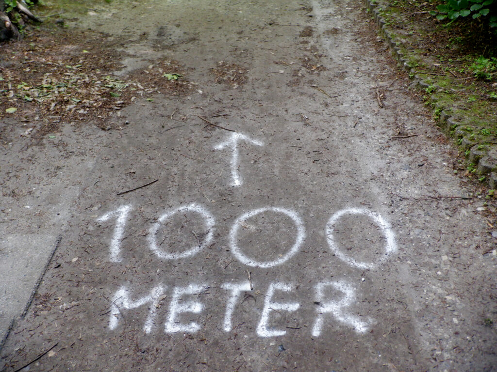 "1000 meter skrevet med sprey på jorden