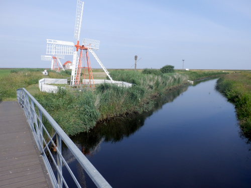 Pumpemøller i landskab med kanal