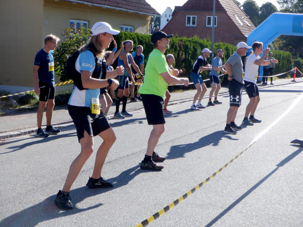 En lille folk løbere varmer op på en vej