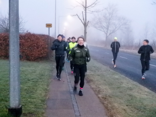 Løbere på et fortorv og på en asfaltvej.