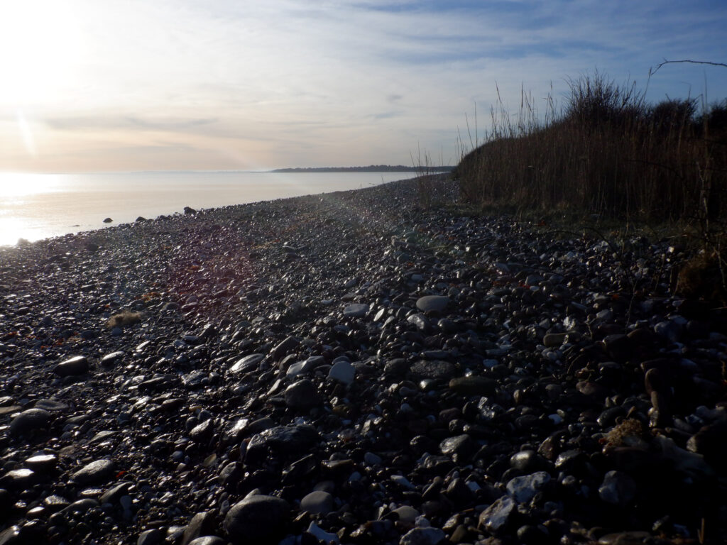 En stenet strand i modlys.