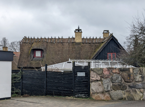 Hus bag en høj mur.