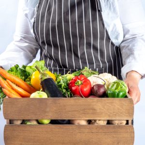 Farmer holding a tray of local produce - Esus Agri Ltd