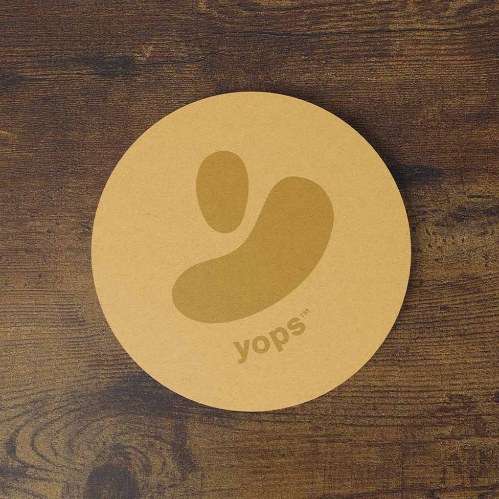 Beer coaster on wooden surface with Yops logo printed on 