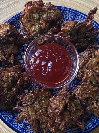 Bord met kanda bhaji en rode saus