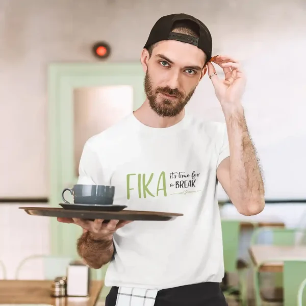 Man serving coffee in a white t-shirt with Fika print