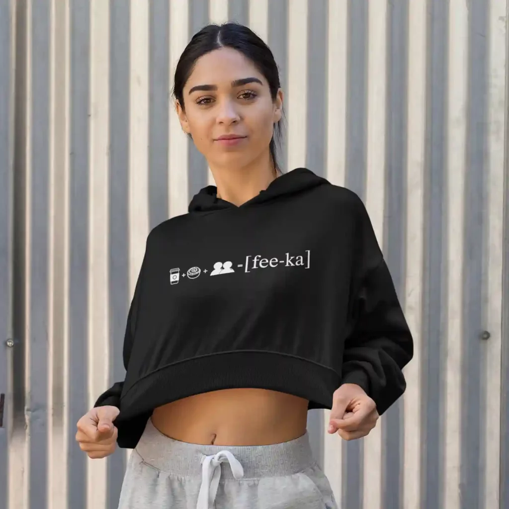 Woman wearing a black crop top hoodie with Fika Rebus print