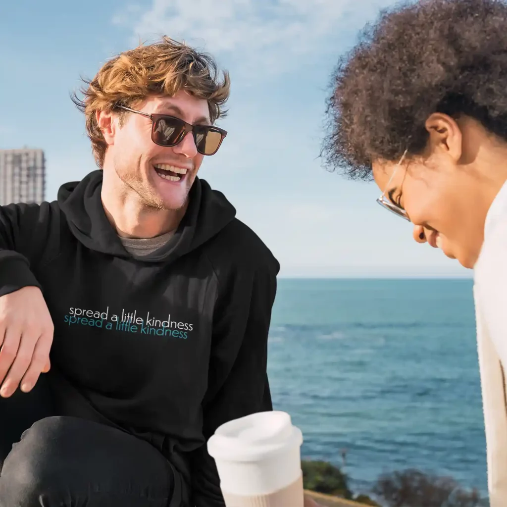 Man wearing a jet black Just Hoods hoodie with dual colour Kindness print