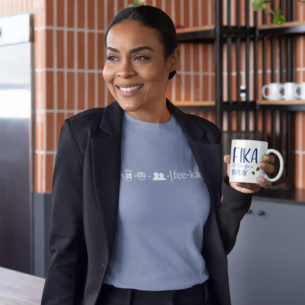 Woman wearing a lavender blue t-shirt with Fika Rebus print