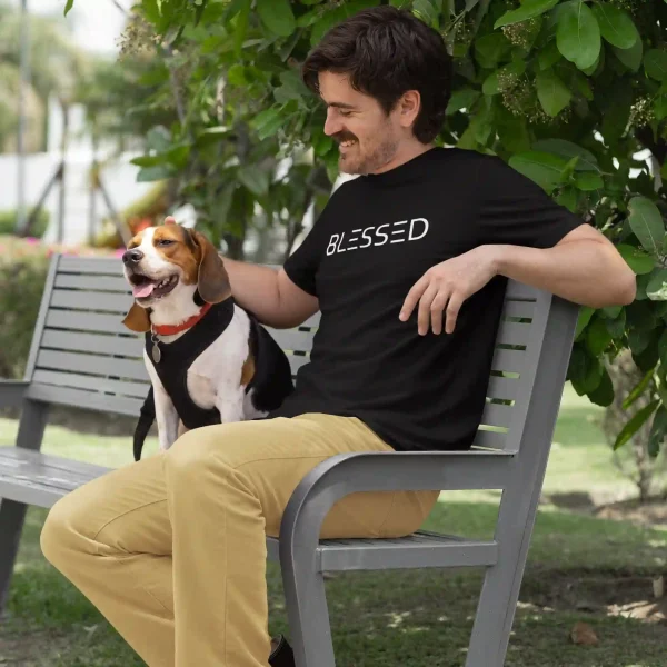 Man with dog wearing a black Bella-Canvas t-shirt with white Blessed print