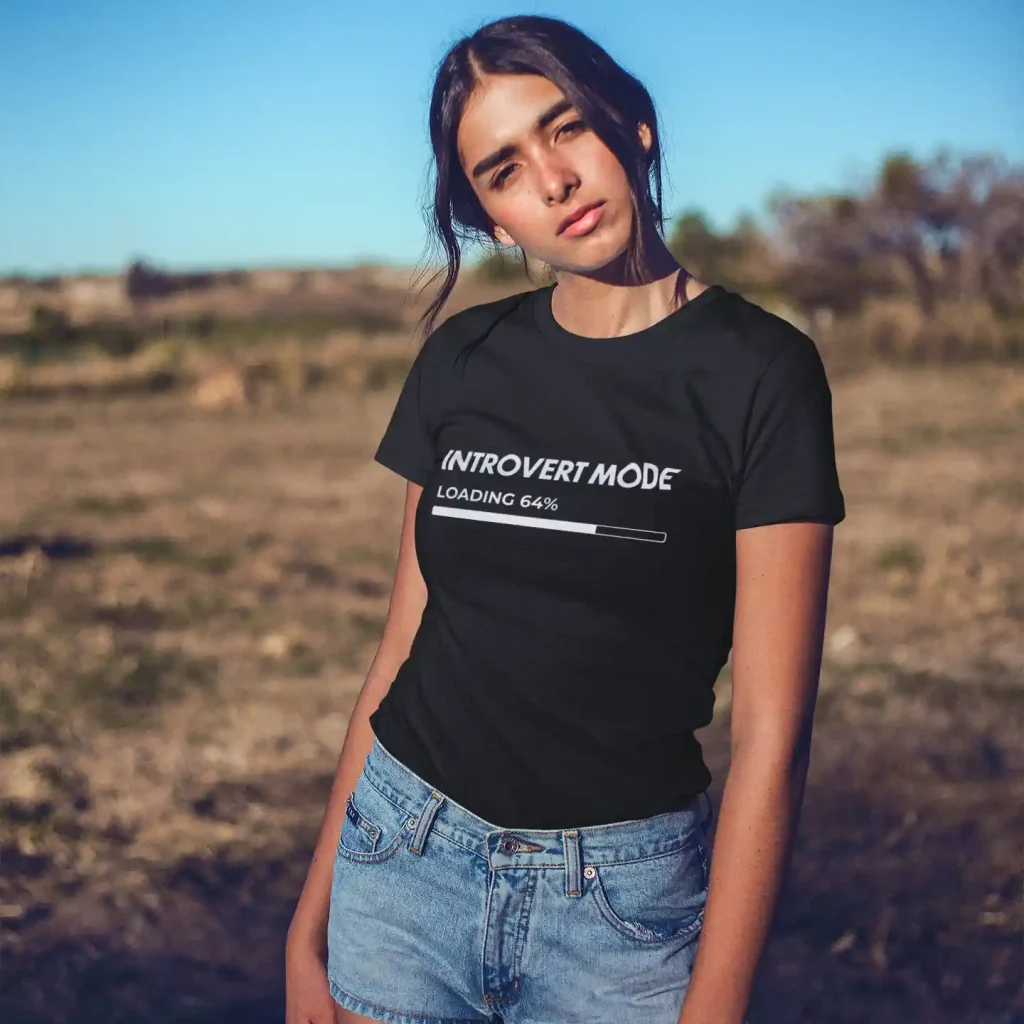 Young woman wearing a black Bella-Canvas t-shirt with white Introvert Mode print